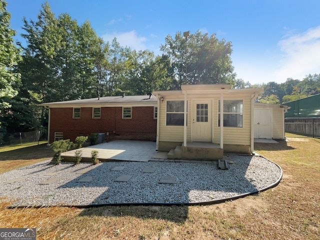 rear view of property with a patio area and a lawn