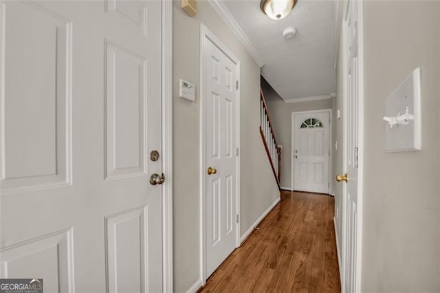 hallway with light hardwood / wood-style flooring and ornamental molding