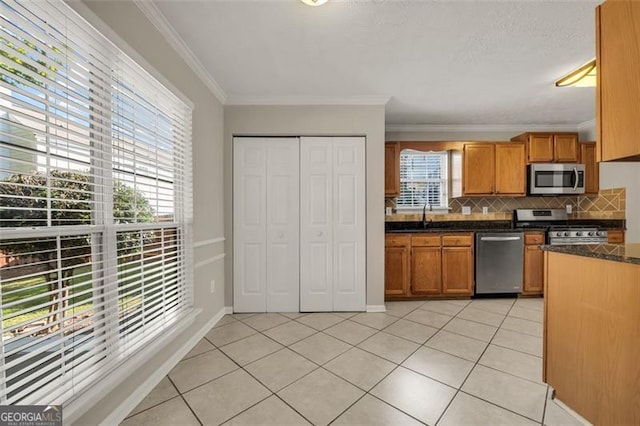 kitchen featuring light tile patterned floors, a wealth of natural light, stainless steel appliances, and decorative backsplash