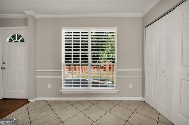 foyer entrance with ornamental molding, plenty of natural light, and light tile patterned floors