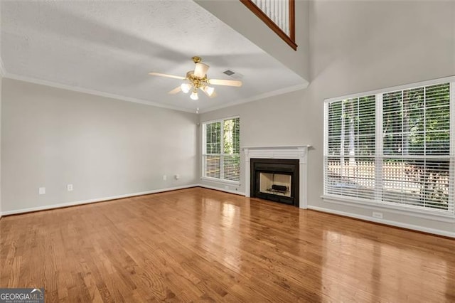 unfurnished living room with light hardwood / wood-style flooring, ceiling fan, and a healthy amount of sunlight