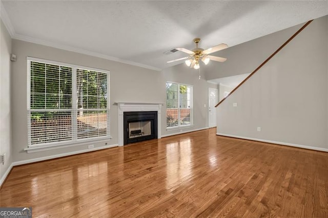 unfurnished living room with hardwood / wood-style floors, ceiling fan, and a healthy amount of sunlight