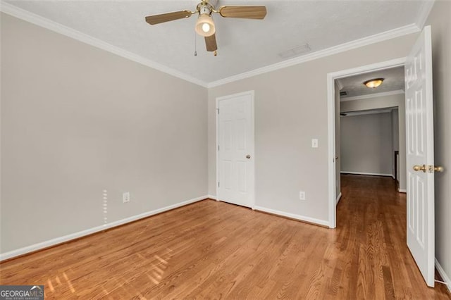 unfurnished bedroom with crown molding, wood-type flooring, ceiling fan, and a closet