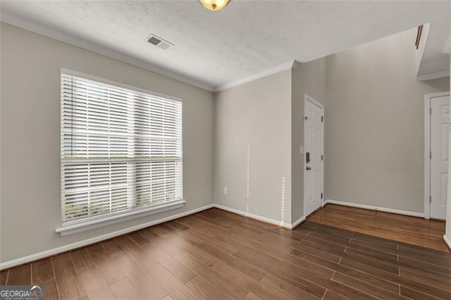 unfurnished bedroom with ornamental molding, a textured ceiling, and dark hardwood / wood-style floors