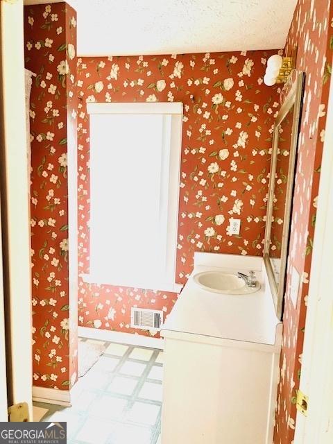 bathroom featuring a textured ceiling and vanity