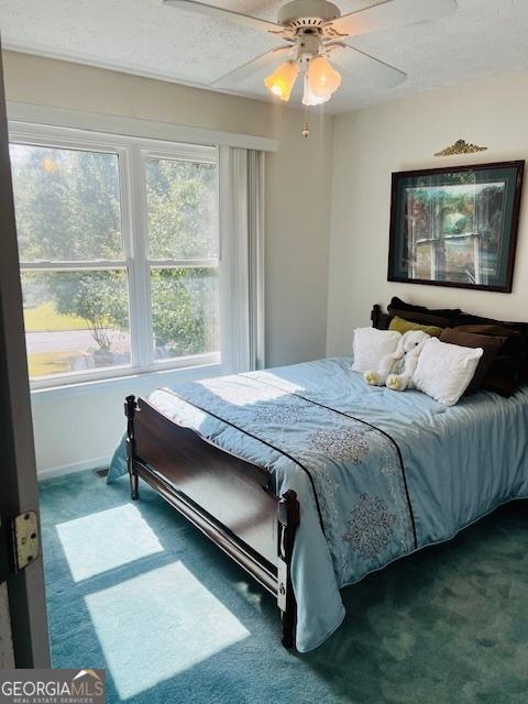 bedroom featuring ceiling fan and carpet