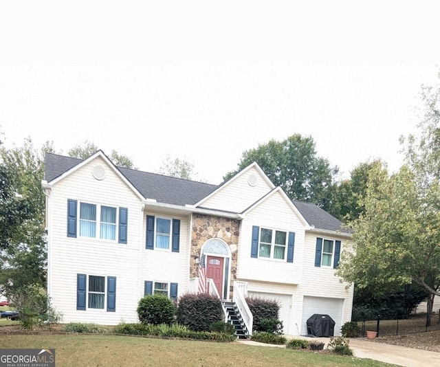 bi-level home featuring a garage and a front lawn