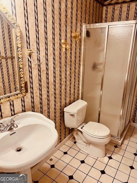 bathroom with sink, an enclosed shower, tile patterned flooring, and toilet