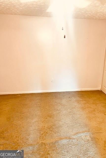 carpeted spare room featuring a textured ceiling