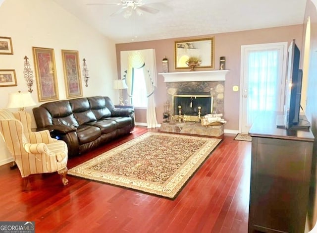 living room featuring ceiling fan, a premium fireplace, lofted ceiling, and hardwood / wood-style flooring