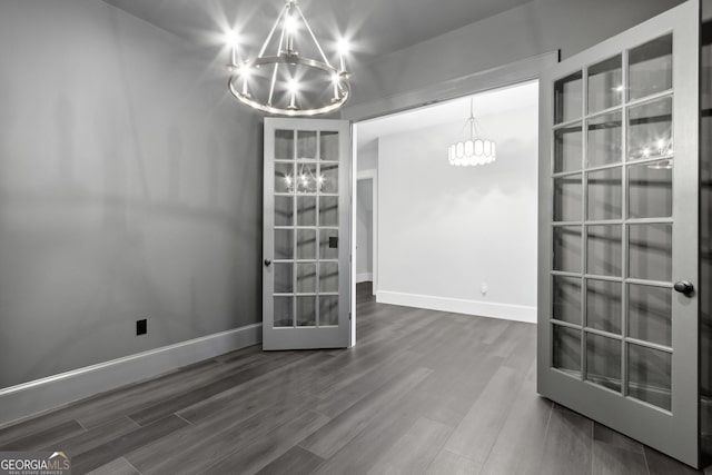 unfurnished dining area featuring hardwood / wood-style floors and a notable chandelier