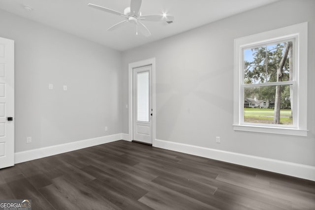 unfurnished room with a wealth of natural light, dark hardwood / wood-style flooring, and ceiling fan