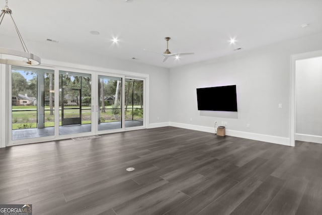 unfurnished living room with dark hardwood / wood-style floors, ceiling fan, and a healthy amount of sunlight