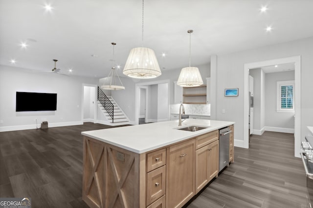 kitchen with a kitchen island with sink, hanging light fixtures, sink, stainless steel dishwasher, and ceiling fan