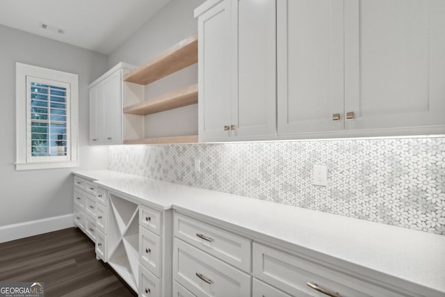 kitchen with decorative backsplash, white cabinetry, and dark wood-type flooring