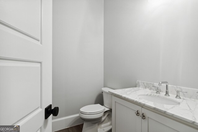 bathroom featuring hardwood / wood-style flooring, vanity, and toilet