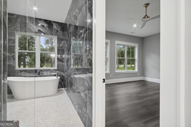 bathroom featuring a bathtub, hardwood / wood-style floors, and tile walls