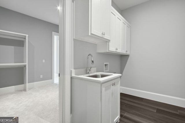 kitchen featuring sink, white cabinetry, and dark wood-type flooring