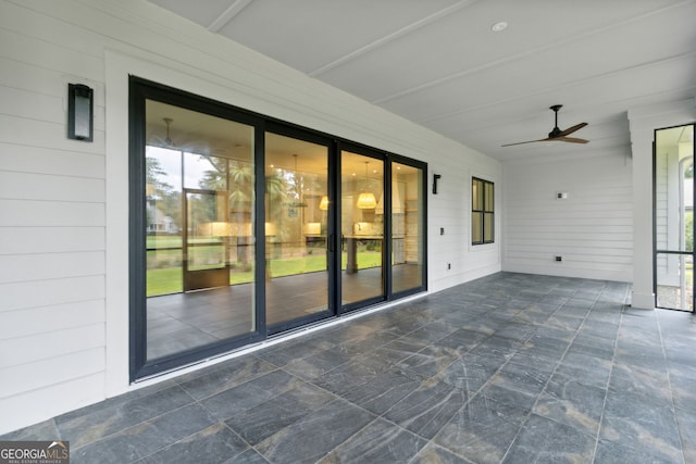 unfurnished sunroom with a wealth of natural light and ceiling fan