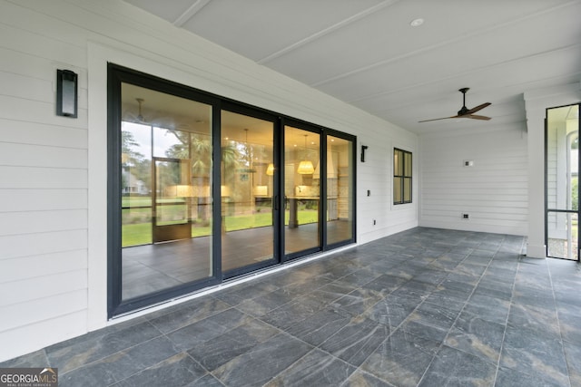 unfurnished sunroom featuring a wealth of natural light and ceiling fan