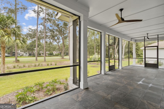 unfurnished sunroom featuring ceiling fan