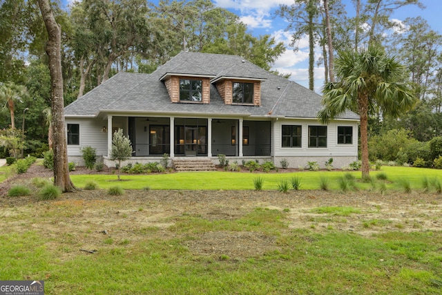 view of front facade with a sunroom and a front lawn