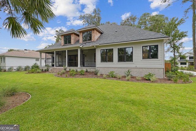 rear view of property featuring a lawn and a sunroom