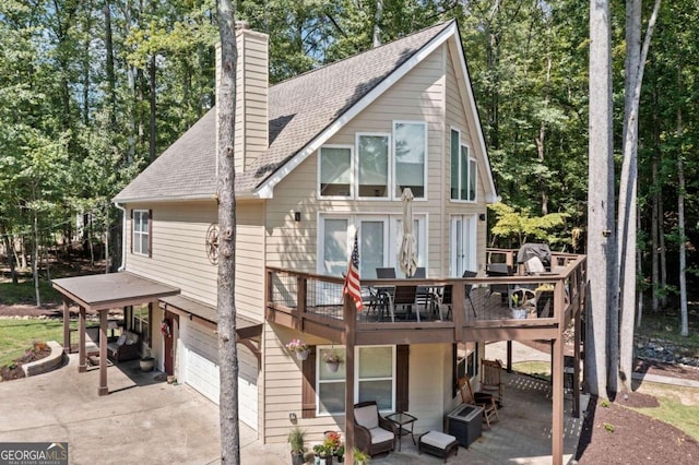 back of house with a wooden deck and a garage