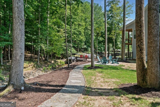 view of property's community featuring an outdoor fire pit and a patio area