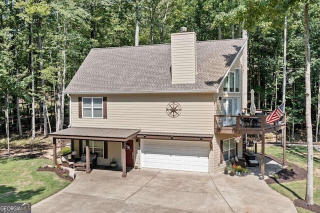 view of front of house with a front yard, a garage, and a deck