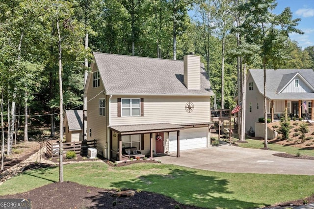 view of front of home with central AC unit, a garage, and a front lawn