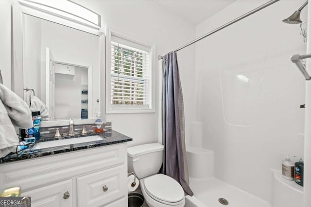 bathroom featuring walk in shower, vanity, and toilet