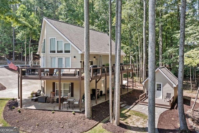 back of property featuring a patio area and a wooden deck