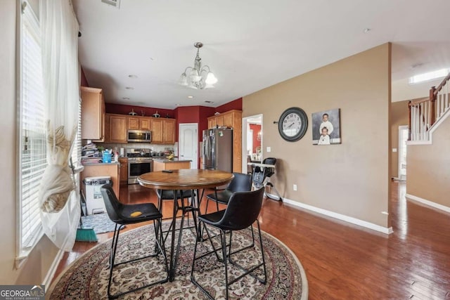 dining area featuring wood-type flooring and a notable chandelier