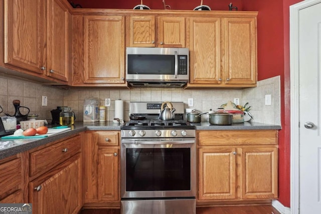 kitchen featuring hardwood / wood-style floors, backsplash, and stainless steel appliances