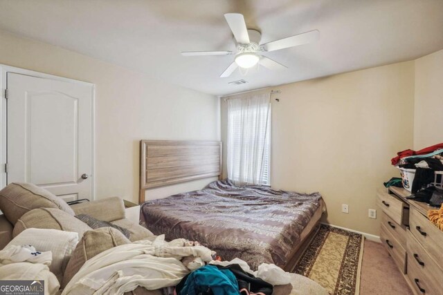 bedroom featuring light colored carpet and ceiling fan