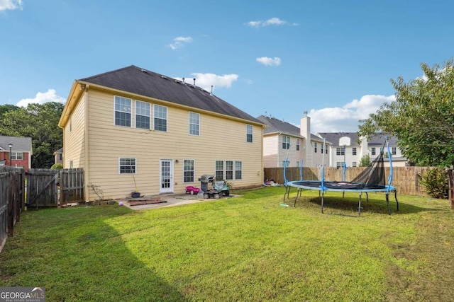 rear view of house featuring a yard, a patio, and a trampoline