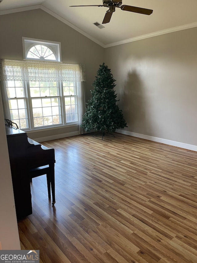 spare room featuring crown molding, vaulted ceiling, hardwood / wood-style floors, and ceiling fan