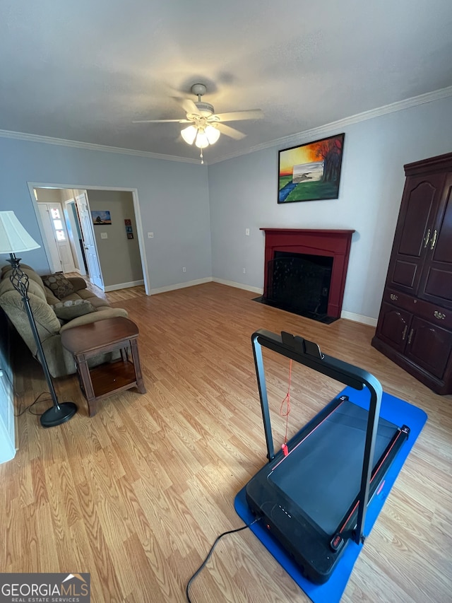 living room featuring crown molding, light hardwood / wood-style flooring, and ceiling fan