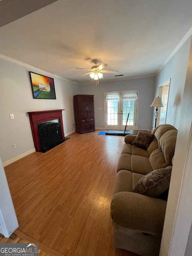 living room with ceiling fan, ornamental molding, and wood-type flooring