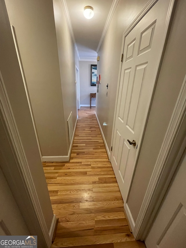 hall featuring ornamental molding and light hardwood / wood-style floors