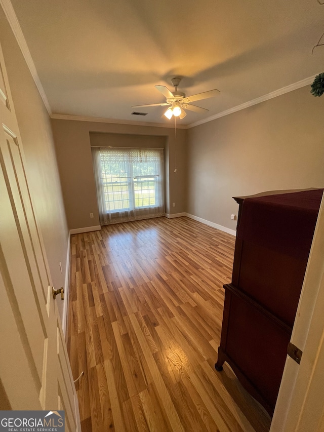 unfurnished room featuring ceiling fan, crown molding, and wood-type flooring