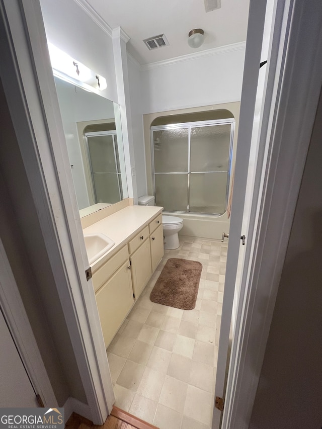 full bathroom with enclosed tub / shower combo, toilet, ornamental molding, and vanity