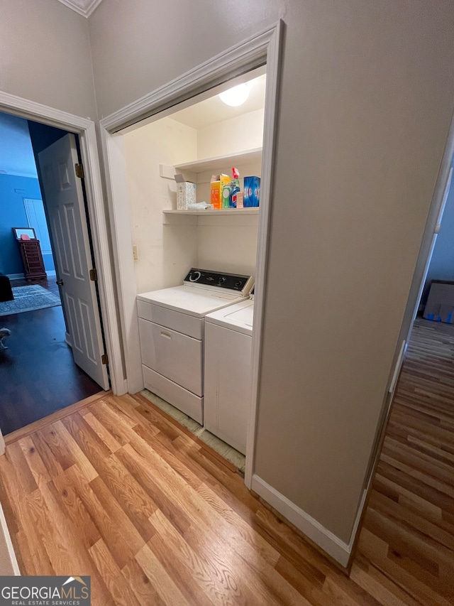 clothes washing area featuring light wood-type flooring and washing machine and dryer