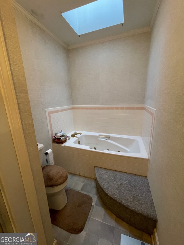 bathroom featuring tiled tub, toilet, tile patterned flooring, ornamental molding, and a skylight