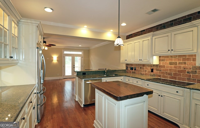 kitchen with stainless steel appliances, dark hardwood / wood-style flooring, sink, a kitchen island, and decorative light fixtures