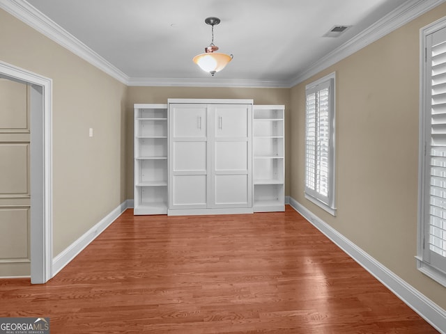 unfurnished bedroom featuring wood-type flooring and ornamental molding