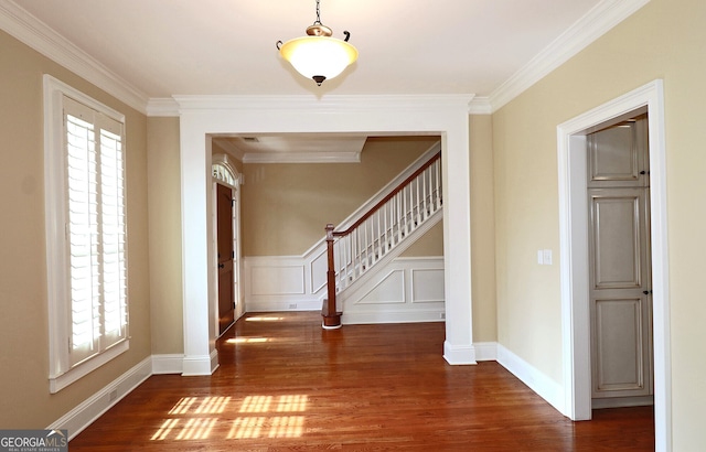 entrance foyer with ornamental molding and dark hardwood / wood-style floors