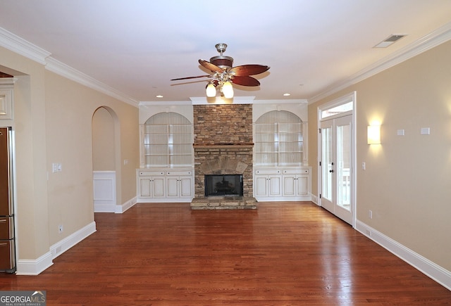 unfurnished living room with a stone fireplace, french doors, ornamental molding, dark hardwood / wood-style floors, and ceiling fan