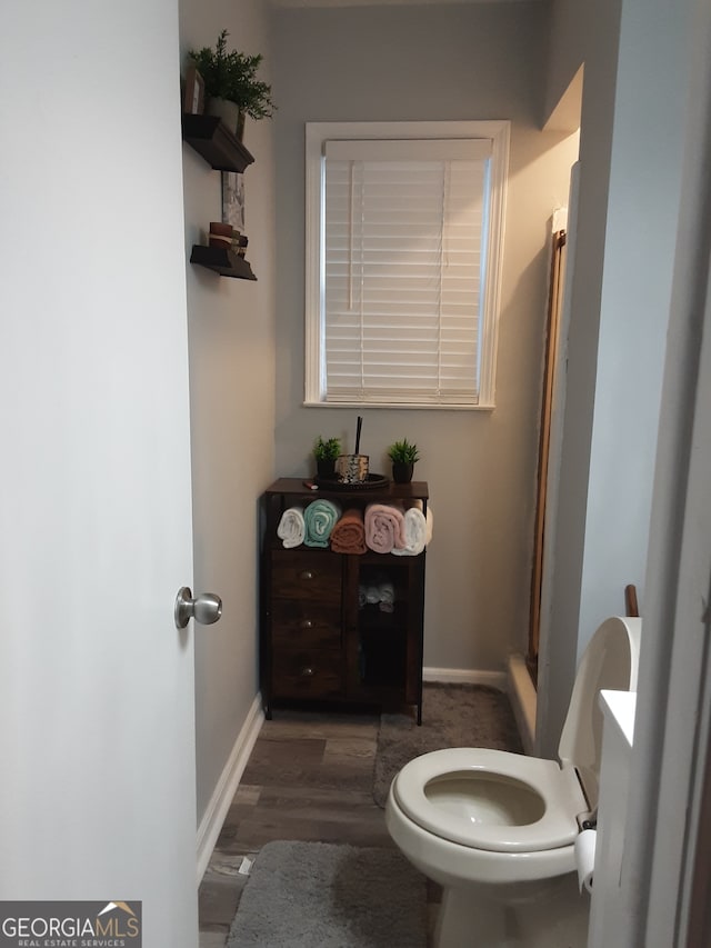 bathroom featuring toilet and wood-type flooring